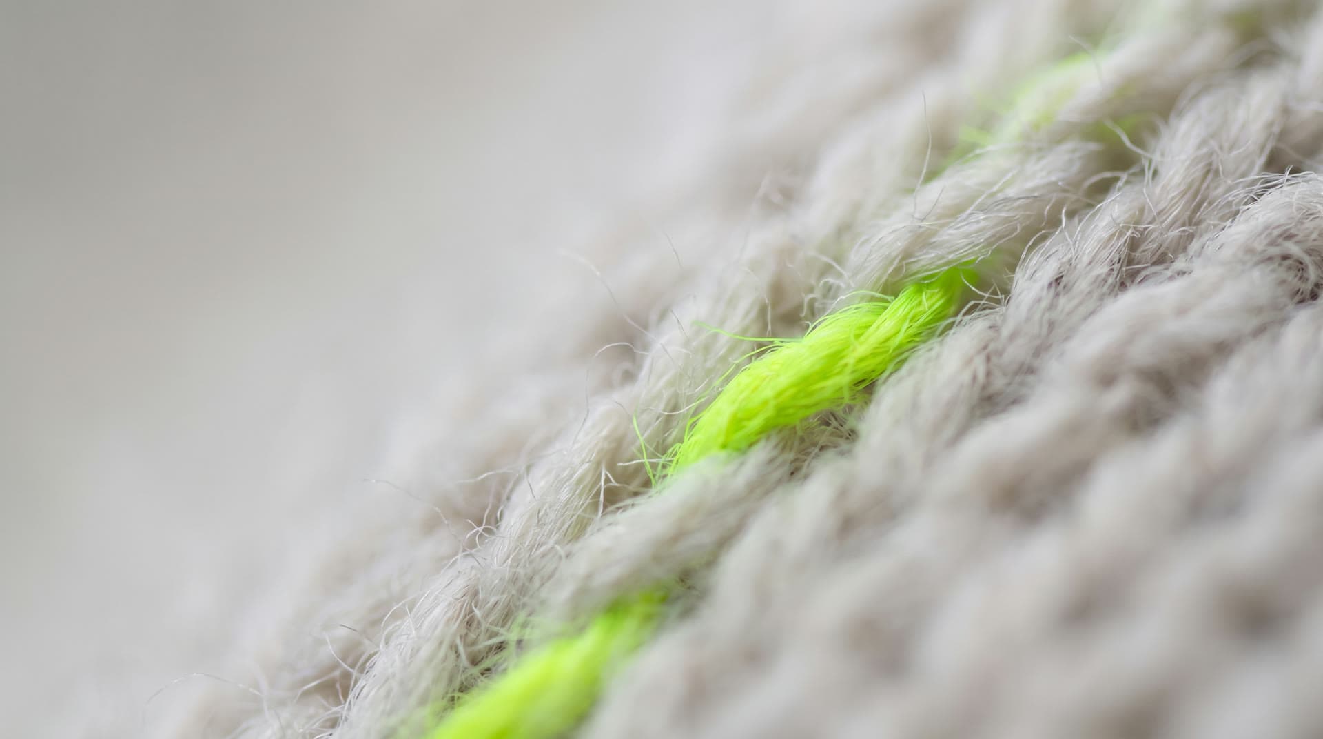 Macro view of knitted fabric with a single toxic green thread — generated for NexTex AI